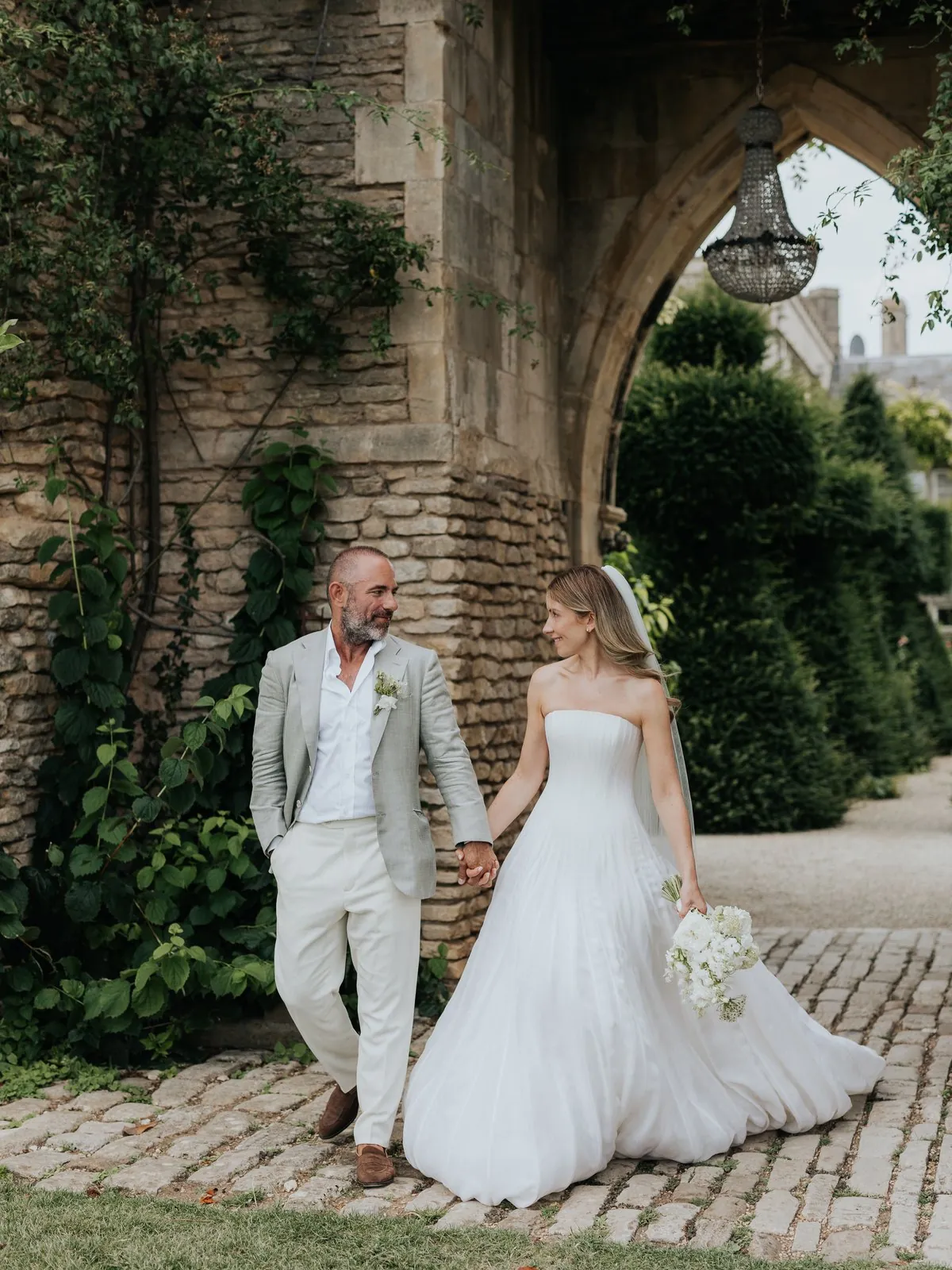 A bride and groom beneath a stone archway at Euridge Manor